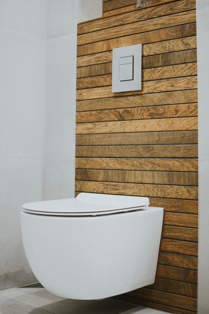 a bathroom with a panelled back wall focusing on the toilet